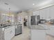 Kitchen offers granite counters, stainless appliances, tile backsplash, white cabinets, and center island at 5325 Cypress Reserve Pl, Winter Park, FL 32792