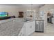 Kitchen boasts granite counters, stainless steel appliances, tiled backsplash, white cabinets, and open layout at 5325 Cypress Reserve Pl, Winter Park, FL 32792