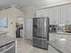 Kitchen featuring stainless refrigerator, granite counters, tile backsplash, and white cabinets at 5325 Cypress Reserve Pl, Winter Park, FL 32792