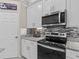 Kitchen featuring stainless oven, microwave, granite counters, tile backsplash, and white cabinets at 5325 Cypress Reserve Pl, Winter Park, FL 32792