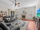 Comfortable living room with a leather sofa, fireplace, and a ceiling fan at 5325 Cypress Reserve Pl, Winter Park, FL 32792