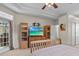 Comfortable main bedroom featuring a TV, built-in shelves, and access to the lanai at 5325 Cypress Reserve Pl, Winter Park, FL 32792