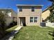 Backyard with an expansive lawn and house with tan siding at 5771 Mangrove Cove Ave, Winter Garden, FL 34787