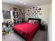 Cozy bedroom with a red comforter, decorative ears on the wall and filled bookcase at 5771 Mangrove Cove Ave, Winter Garden, FL 34787