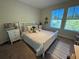 Sunlit bedroom with a white bed and large windows offering outdoor views at 5771 Mangrove Cove Ave, Winter Garden, FL 34787