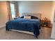 Comfortable bedroom featuring a large bed with a blue comforter, bedside tables, and soft lighting at 5771 Mangrove Cove Ave, Winter Garden, FL 34787