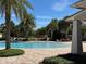 Relaxing community pool area featuring lush palm trees, sun loungers, and a tranquil setting at 5771 Mangrove Cove Ave, Winter Garden, FL 34787