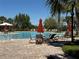 Well-appointed community pool with comfortable seating, umbrellas, and tropical landscaping at 5771 Mangrove Cove Ave, Winter Garden, FL 34787
