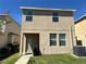 Two-story tan house featuring a well-maintained yard and neutral exterior paint at 5771 Mangrove Cove Ave, Winter Garden, FL 34787