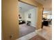View into living room featuring neutral carpet, piano, dark couch, and light walls at 5771 Mangrove Cove Ave, Winter Garden, FL 34787