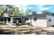 Rear view of a gray and white house with a fenced yard and mature trees at 5830 Beechmont Blvd, Orlando, FL 32808