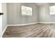 Bright bedroom featuring new wood-look flooring, and two windows at 5830 Beechmont Blvd, Orlando, FL 32808