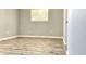 Bright bedroom with neutral walls, white trim, and laminate flooring, centered by a single window at 5830 Beechmont Blvd, Orlando, FL 32808