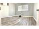 Empty bedroom featuring new wood-look floors, a window, and a built-in closet at 5830 Beechmont Blvd, Orlando, FL 32808