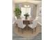 Sunlit dining room with hardwood floors, a round table, and six chairs, exuding a cozy charm at 5830 Beechmont Blvd, Orlando, FL 32808