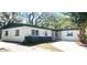 Charming single story home with white siding, a dark gray base, a dark roof, and a spacious driveway at 5830 Beechmont Blvd, Orlando, FL 32808