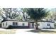 Inviting single story home featuring white siding, dark gray base, and a vibrant red front door at 5830 Beechmont Blvd, Orlando, FL 32808