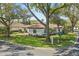 Stunning single-story home with a lush green lawn, mature trees, and a classic red tile roof at 6120 Payne Stewart Dr, Windermere, FL 34786