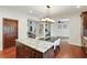 Kitchen island with white marbled countertop and dark cabinetry, with a view to the living room at 6120 Payne Stewart Dr, Windermere, FL 34786