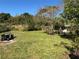 Expansive lawn, trees and shrubbery with outdoor seating in the backyard at 655 Katherine Ave, Orlando, FL 32810