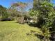 Large backyard with vibrant green grass, trees and shrubbery, plus outdoor seating at 655 Katherine Ave, Orlando, FL 32810