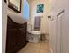 Bathroom featuring dark wood vanity, toilet, and tile flooring beneath a window with blinds at 655 Katherine Ave, Orlando, FL 32810
