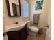 Bathroom featuring dark wood vanity, toilet, and tile flooring beneath a window with blinds at 655 Katherine Ave, Orlando, FL 32810