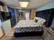 Bedroom featuring a large, upholstered bed, light fixtures, and laminate flooring at 655 Katherine Ave, Orlando, FL 32810