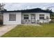 Charming single-story home featuring a well-maintained lawn and a cozy front porch with chairs at 655 Katherine Ave, Orlando, FL 32810