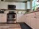 Well-lit kitchen showcasing stainless steel appliances and ample white cabinetry at 655 Katherine Ave, Orlando, FL 32810