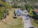 Aerial view of a charming home with lush landscaping, a long driveway, and mature palm trees at 709 S Parsons Ave, Deland, FL 32720