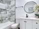 Bathroom featuring marble-look tile, tub, and a white vanity with modern finishes at 709 S Parsons Ave, Deland, FL 32720