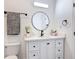 Bright bathroom featuring a white vanity, round mirror, and decorative towel with modern finishes at 709 S Parsons Ave, Deland, FL 32720