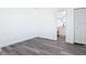 Bedroom with neutral walls, wood-look flooring, and a glimpse of the ensuite bathroom at 709 S Parsons Ave, Deland, FL 32720