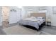Cozy bedroom featuring gray floors, a tufted headboard, and a view into the ensuite bathroom at 709 S Parsons Ave, Deland, FL 32720