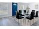 Contemporary dining room with a glass table, black chairs, and a blue front door at 709 S Parsons Ave, Deland, FL 32720