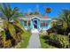 Charming turquoise home with an American flag, lush landscaping, and a welcoming pathway at 723 Dougherty St, New Smyrna Beach, FL 32168