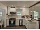 Well-lit kitchen boasts white cabinets, modern appliances, and quartz countertops at 723 Dougherty St, New Smyrna Beach, FL 32168