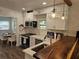 Updated kitchen features white cabinets, stone countertops, stainless appliances, and hanging glass pendant lights at 723 Dougherty St, New Smyrna Beach, FL 32168