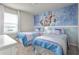 Bright and airy bedroom featuring two twin beds and a Frozen-themed accent wall at 7376 Oakmoss Loop, Davenport, FL 33837