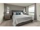 Spacious bedroom featuring a tufted headboard, plush carpet, and abundant natural light at 7376 Oakmoss Loop, Davenport, FL 33837