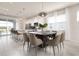 Open-concept dining area with modern table and view to the outdoor pool and patio at 7376 Oakmoss Loop, Davenport, FL 33837