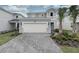 Charming two-story home featuring a two-car garage, lush landscaping and a welcoming front entrance at 7376 Oakmoss Loop, Davenport, FL 33837