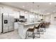 Bright kitchen with stainless steel appliances, white cabinetry, granite countertops, and seating at the island at 7376 Oakmoss Loop, Davenport, FL 33837