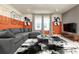 Comfortable living room boasts a modern sectional, stylish decor, and plenty of natural light at 7376 Oakmoss Loop, Davenport, FL 33837