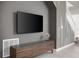 Living room featuring a modern entertainment center and unique wall accents next to stairway at 7376 Oakmoss Loop, Davenport, FL 33837
