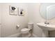 Stylish powder room features a pedestal sink, modern fixtures and artistic decor at 7376 Oakmoss Loop, Davenport, FL 33837