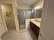 Comfortable bathroom with a glass door shower and granite countertop vanity at 7609 Brookhurst Ln, Kissimmee, FL 34747