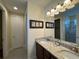 Bathroom boasts double sinks, granite countertops, framed art, and a glass-enclosed shower at 7609 Brookhurst Ln, Kissimmee, FL 34747