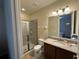 Bathroom featuring a glass enclosed shower, granite counter, and modern fixtures at 7609 Brookhurst Ln, Kissimmee, FL 34747